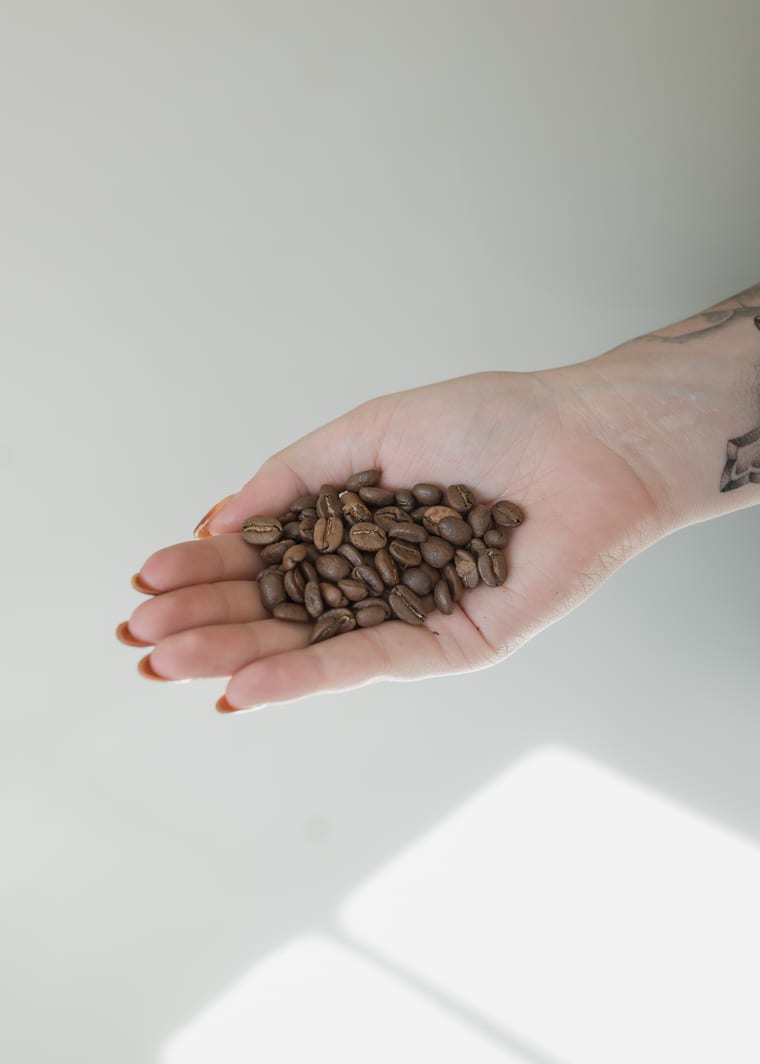 A handful of roasted coffee beans held in an open hand