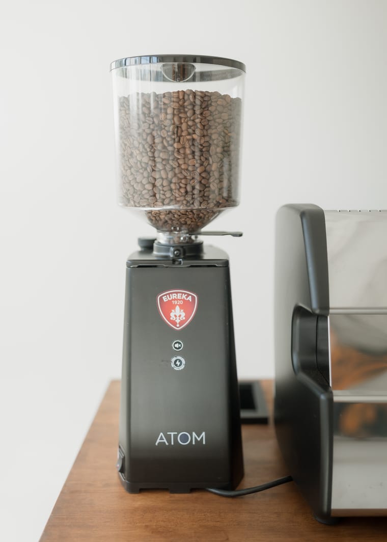 The coffee grinder on the cart, full of beans.