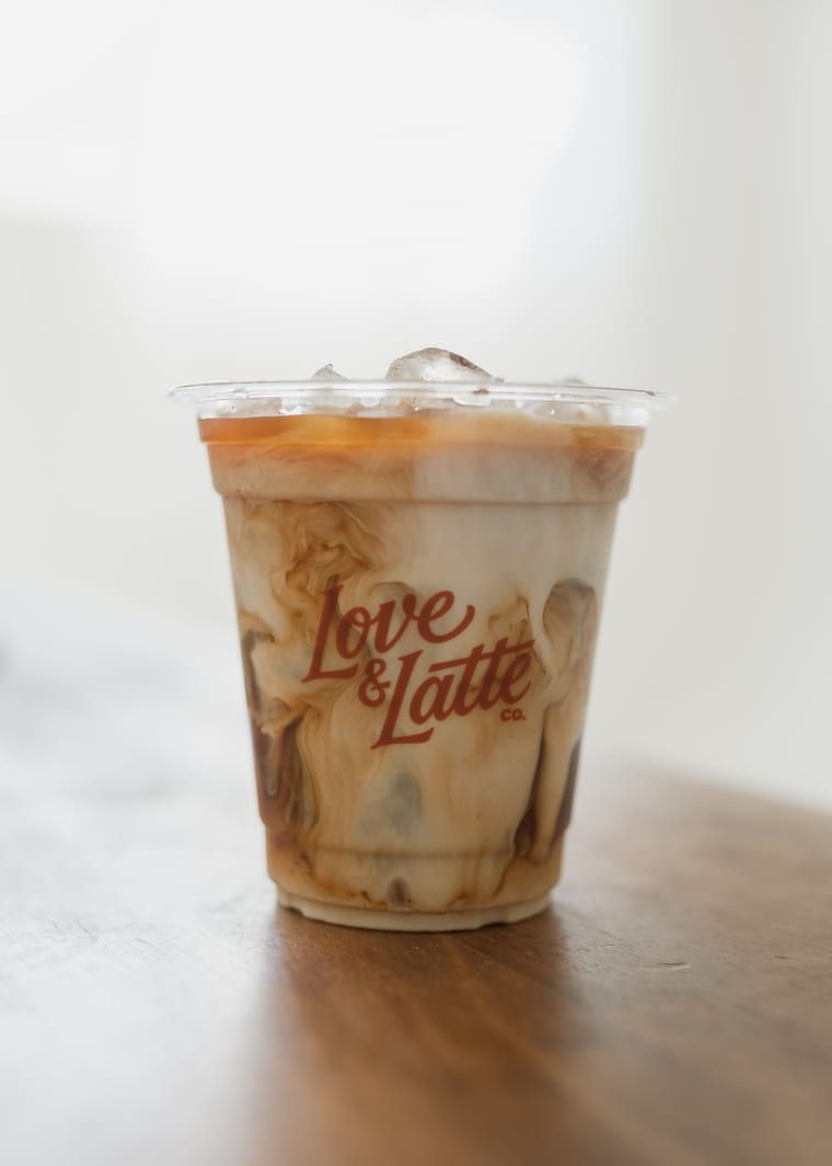 An iced coffee in a branded Love and Latte cup.